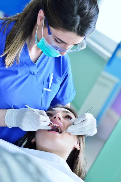 Dentista femenino examinando los dientes del paciente — Foto de Stock