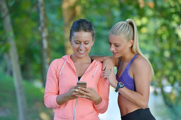 Duas mulheres fazendo pausa usando o telefone — Fotografia de Stock