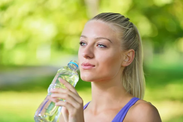 Athletic woman drinks water