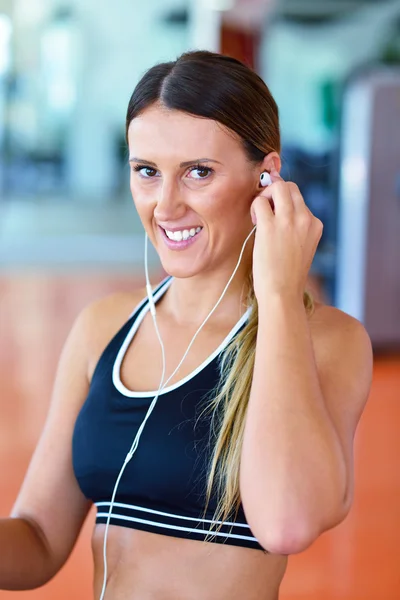 Mulher colocando fones de ouvido antes do exercício — Fotografia de Stock