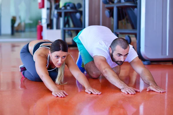 Woman stretching with personal trainer