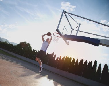 Atlama ve stree oynayan bir fantastik slam dunk yapma genç adam