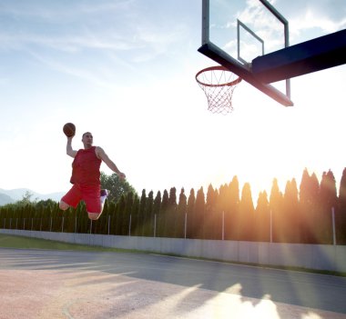 Atlama ve stree oynayan bir fantastik slam dunk yapma genç adam