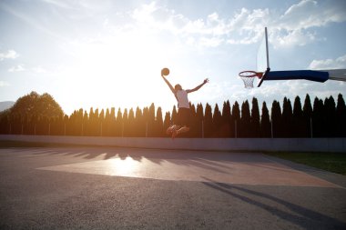 Atlama ve stree oynayan bir fantastik slam dunk yapma genç adam