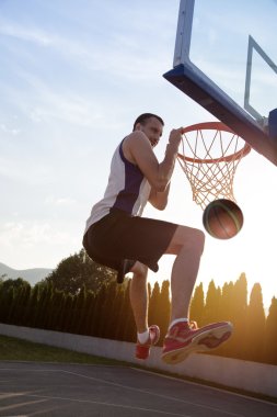 Atlama ve stree oynayan bir fantastik slam dunk yapma genç adam