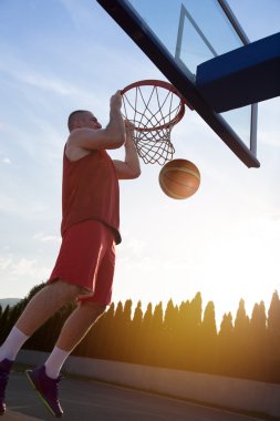Atlama ve stree oynayan bir fantastik slam dunk yapma genç adam