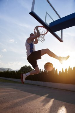Atlama ve stree oynayan bir fantastik slam dunk yapma genç adam