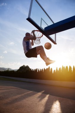 Atlama ve stree oynayan bir fantastik slam dunk yapma genç adam