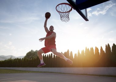 Atlama ve stree oynayan bir fantastik slam dunk yapma genç adam
