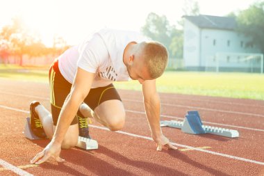Atletik adam güneş ışınları koşu başlamak üzere