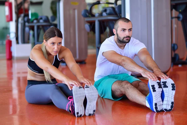 Vrouw rekken met personal trainer — Stockfoto