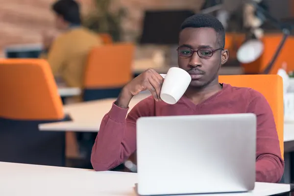 Afrikanischer Geschäftsmann tippt auf Laptop. — Stockfoto