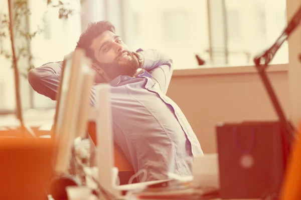 Jovem empresário descontraído no local de trabalho — Fotografia de Stock