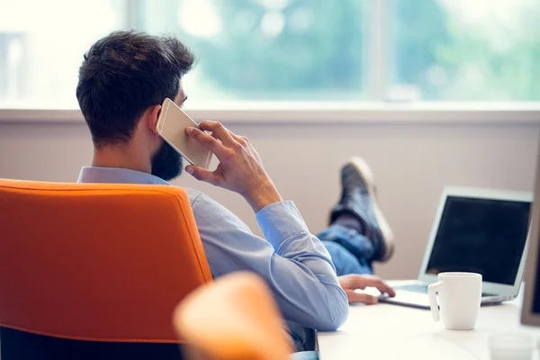 Jovem empresário descontraído no local de trabalho — Fotografia de Stock