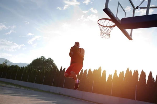 Jovem pulando e fazendo um fantástico slam dunk jogando stree — Fotografia de Stock