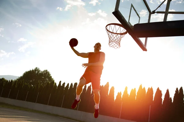 Jovem pulando e fazendo um fantástico slam dunk jogando stree — Fotografia de Stock