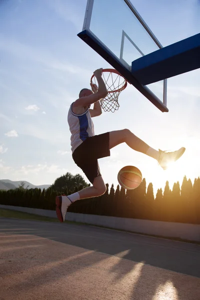 Young man jumping and making a fantastic slam dunk playing stree — Φωτογραφία Αρχείου