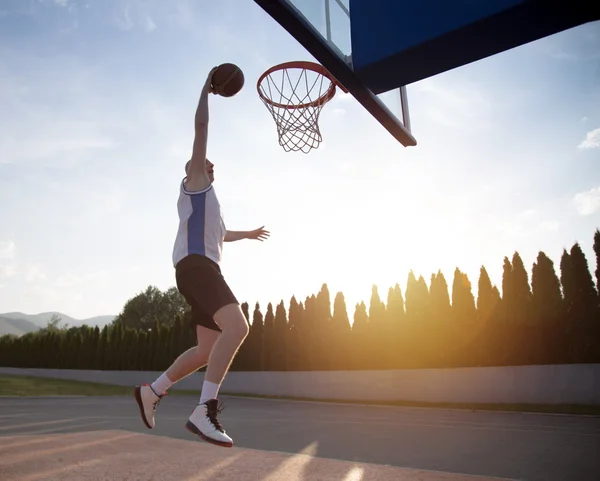 Jovem pulando e fazendo um fantástico slam dunk jogando stree — Fotografia de Stock