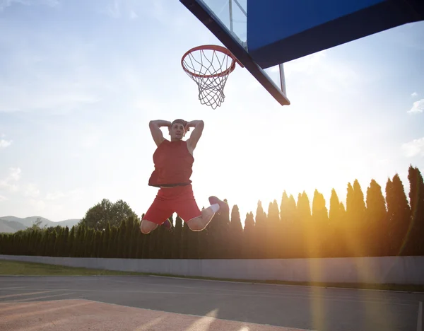 Young man jumping and making a fantastic slam dunk playing stree — ストック写真