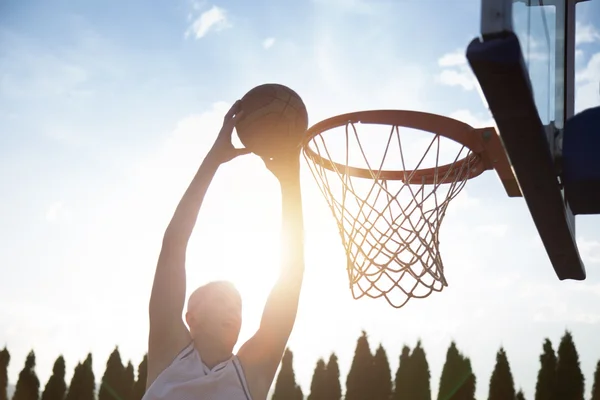 Young man jumping and making a fantastic slam dunk playing stree — ストック写真