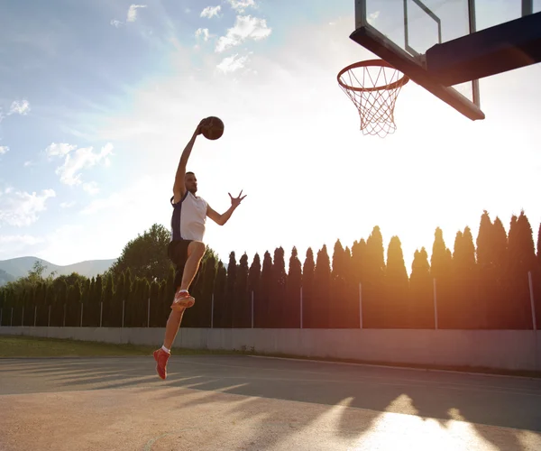 Młody człowiek skoki i Dokonywanie fantastyczne slam dunk gra stree — Zdjęcie stockowe