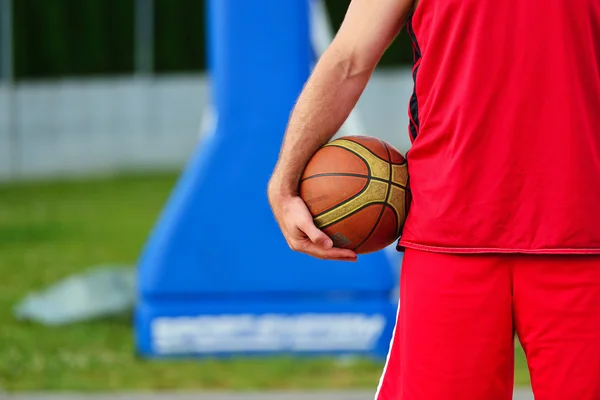 Streetball player with basketball ball outdoors. — Stock fotografie