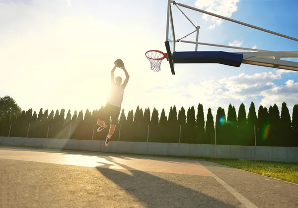 飞向 rim 灌篮的年轻篮球运动员. — 图库照片
