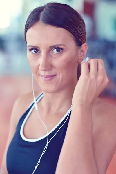 Mulher definir música no telefone inteligente colocando fones de ouvido antes do exercício — Fotografia de Stock