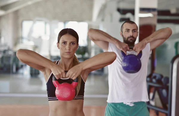 Kettlebells columpio ejercicio de hombre y mujer en el gimnasio — Foto de Stock