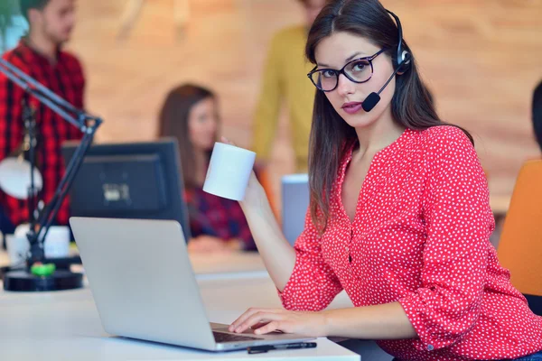 Cute female office worker wearing headset — Stock Photo, Image