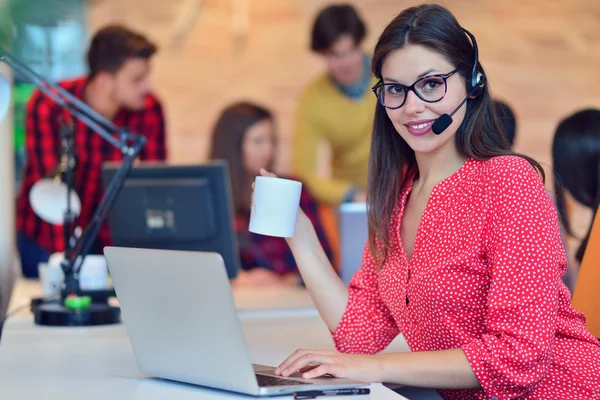 Cute female office worker wearing headset — Stock Photo, Image