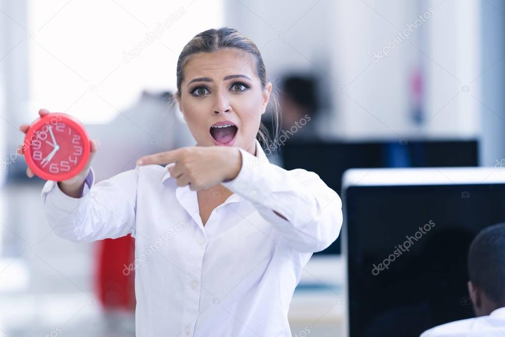 Businesswoman with clock at office