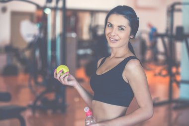 bir elma ve bir şişe su tutarak spor Bayan