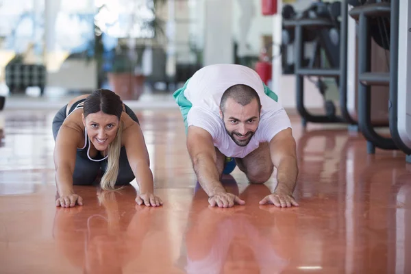 Hombre y mujer haciendo ejercicio en el gimnasio — Foto de Stock