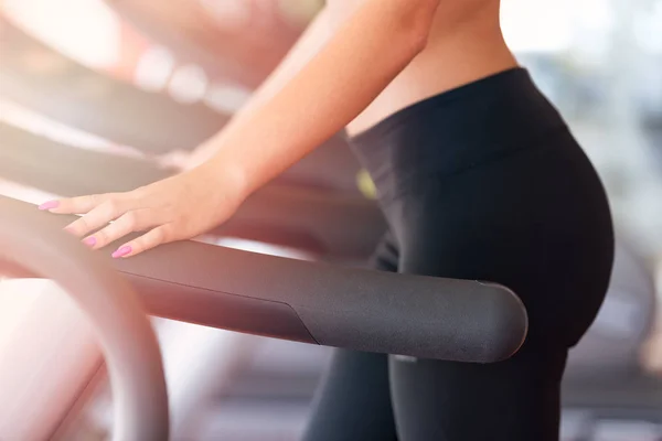 Vrouw met fles water uit te oefenen op de loopband in de sportschool — Stockfoto