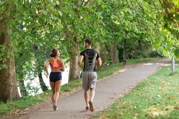 Young couple running in park — Stock Photo, Image