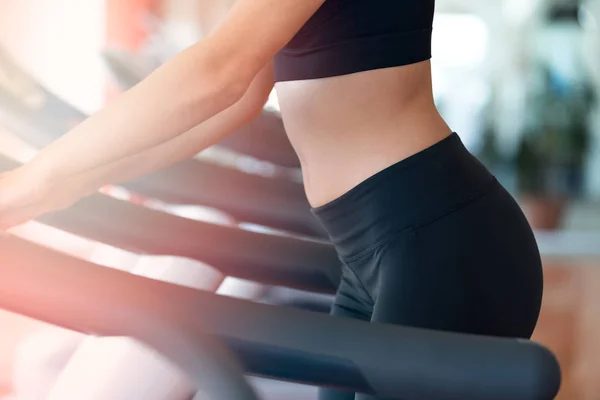 Vrouw met fles water uit te oefenen op de loopband in de sportschool — Stockfoto