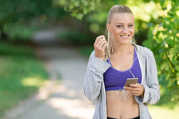 Mujer deportiva utilizando el teléfono inteligente — Foto de Stock