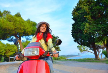 Bir scooter üzerinde çekici mutlu kadın