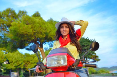 Bir scooter üzerinde çekici mutlu kadın