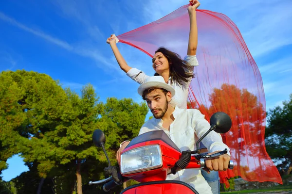 Hermosa pareja joven montando en un scooter — Foto de Stock