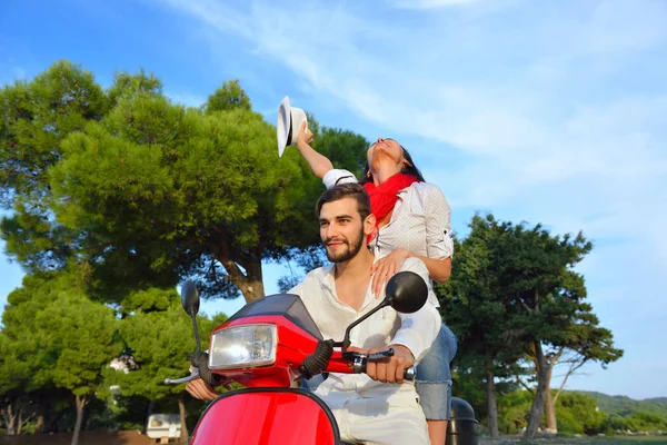 Hermosa pareja joven montando en un scooter — Foto de Stock