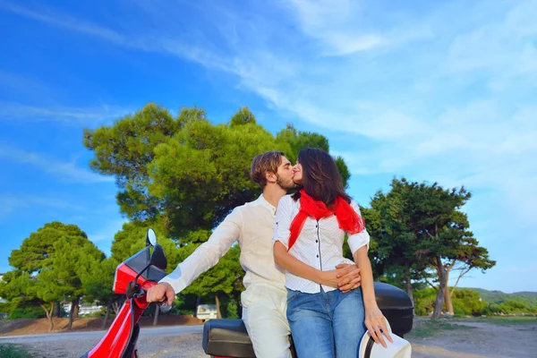 Feliz joven pareja en scooter en un parque — Foto de Stock