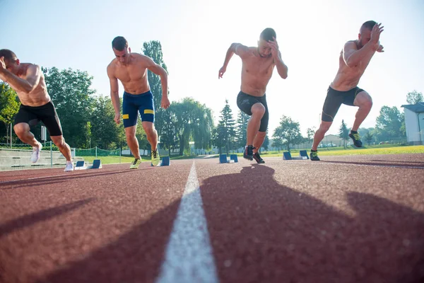 Male athletics runners on starting line without shirts. — Stock Photo, Image