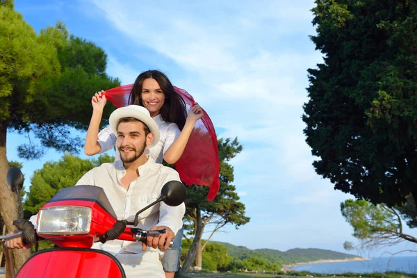 Hermosa pareja joven montando en un scooter — Foto de Stock