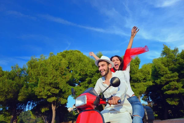 Hermosa pareja joven montando en un scooter — Foto de Stock