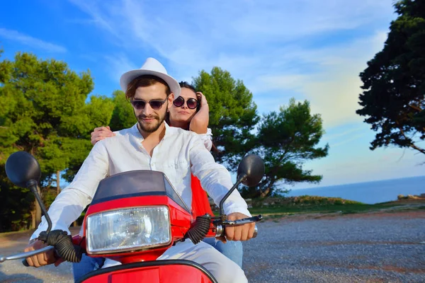 Hermosa pareja joven montando en un scooter — Foto de Stock
