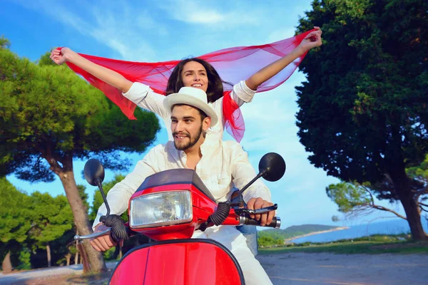 Hermosa pareja joven montando en un scooter — Foto de Stock