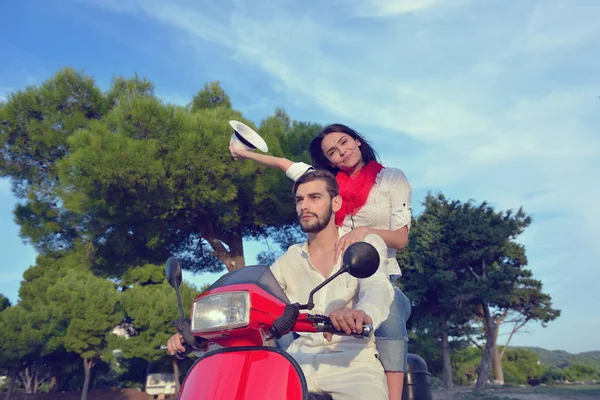 Hermosa pareja joven montando en un scooter — Foto de Stock