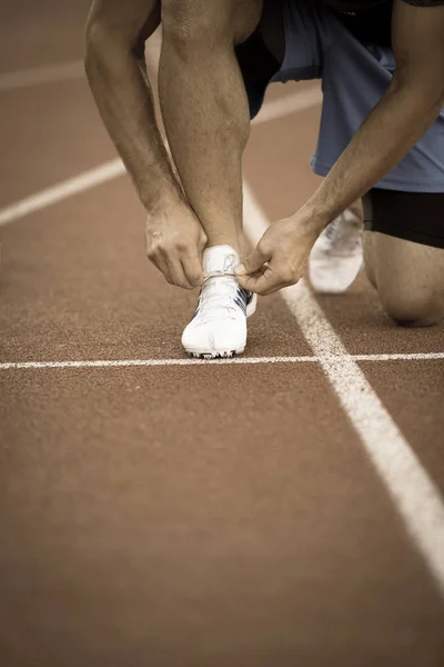 Чоловік-спортсмен зав'язує шнурки для бігу . — стокове фото